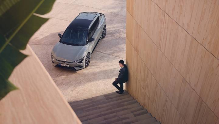 Ein Mann steht neben dem Kia EV6